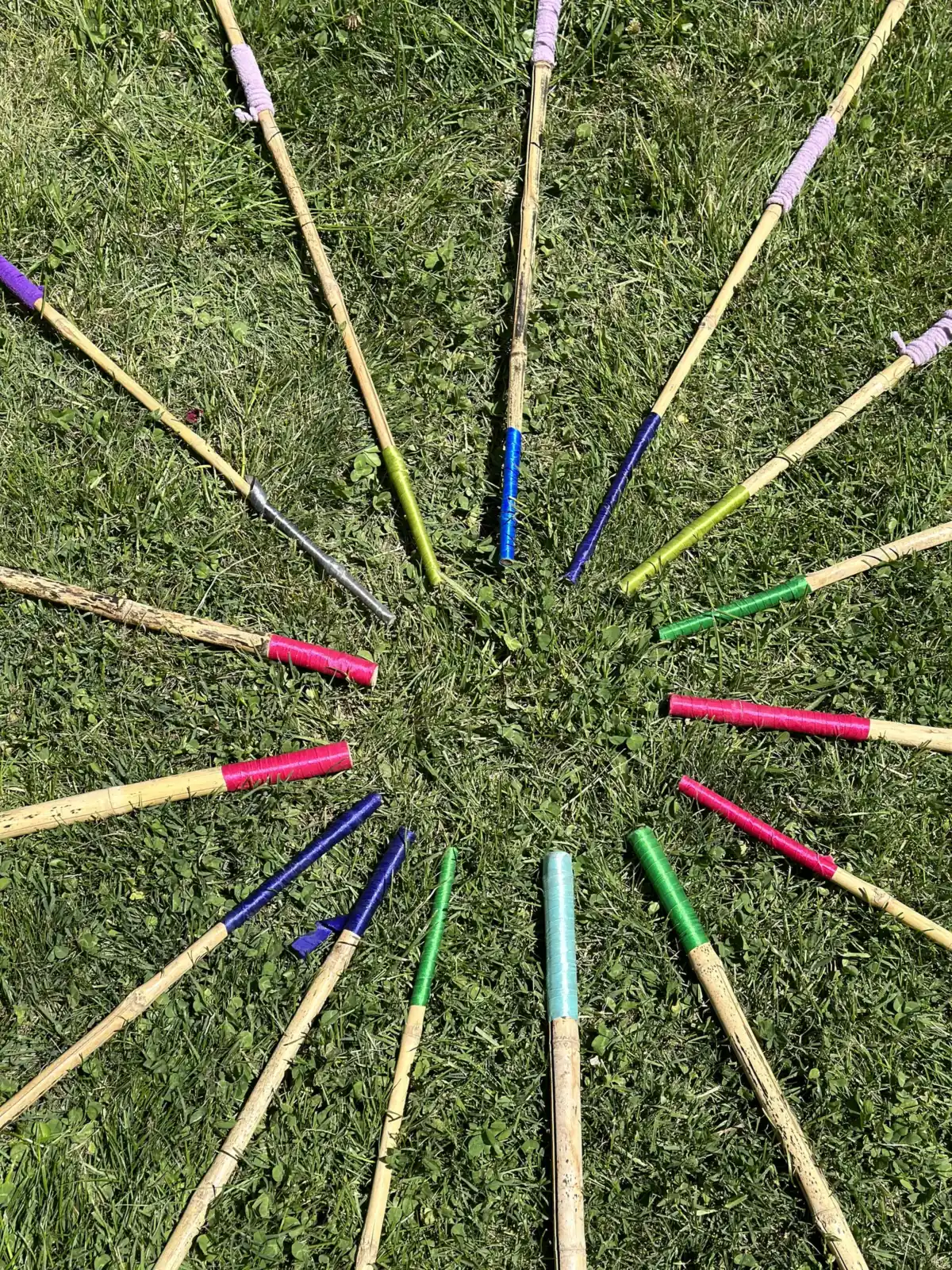 Círculo de palos de colores sobre el pasto, creado durante una experiencia Juegarte