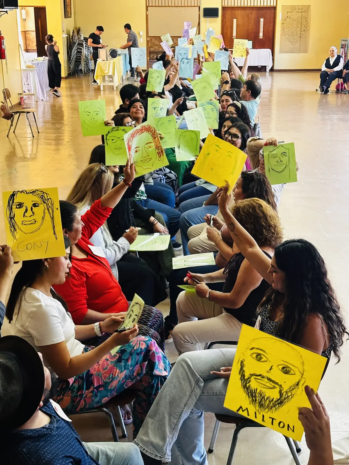 Participantes sosteniendo retratos dibujados durante un taller